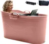 A woman is sitting in a pink portable bathtub, with a laptop and bath tray on top. Náhled obrázku produktu