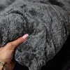 A hand is shown touching a soft, gray, textured fabric, likely a pet bed. Anteprima dell’immagine prodotto