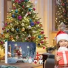 A Christmas tree and advent calendar are set up in a festive living room, with a young girl holding a gift. Produktbild-Vorschau
