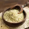 Hemp seeds in a wooden bowl with a wooden scoop. Produktbild-Vorschau