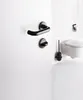 A black toilet brush holder and a white wall-mounted toilet are shown in a bathroom setting. Produktbild-Vorschau