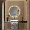 A modern bathroom vanity with a round LED mirror, sink, and decorative elements. Náhled obrázku produktu