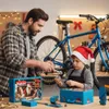 A father and son are working on a bicycle in a workshop decorated for Christmas. Anteprima dell’immagine prodotto