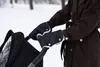 A person pushing a stroller in the snow, wearing hand warmers on the stroller handles. Náhľad obrázku produktu