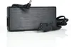 A black power adapter with cables and plugs, shown on a white reflective surface. Produktbild-Vorschau