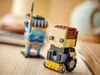 Two LEGO BrickHeadz figures are displayed on a wooden surface, with a blurred background. Náhled obrázku produktu