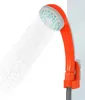 A portable shower head with water spraying from it, mounted on a wall with a suction cup holder. Náhled obrázku produktu