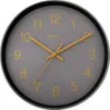 A close-up view of a wall clock with a gray face and yellow numbers and hands. Produktbild-Vorschau