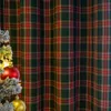 A close-up of a green and red plaid curtain with a Christmas tree and ornaments in the foreground. Voir les images du produit