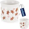 A white ceramic mug with a gingerbread man pattern and a product tag. Náhľad obrázku produktu