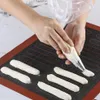 A person is using a piping bag to decorate a baking mat with cream. Podgląd zdjęcia produktu