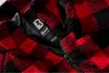 A close-up view of a red and black plaid jacket with a zipper and a brand label. Produktbild-Vorschau