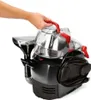 A hand is shown holding the handle of a cleaning appliance. Voir les images du produit