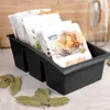 A black organizer filled with spice packets sits on a wooden surface, with bay leaves scattered around it. Náhľad obrázku produktu