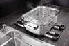 A pot of boiling water is placed on a drying rack over a kitchen sink. Náhled obrázku produktu