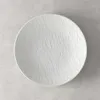 A white plate with a textured surface is shown from a top-down view on a light gray background. Podgląd zdjęcia produktu
