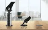 Three stages of a pop-up power outlet installation and use are shown on a wooden desk. Produktbild-Vorschau