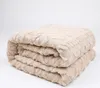 A folded beige blanket with a textured pattern is shown against a white background. Anteprima dell’immagine prodotto
