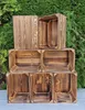 A stack of wooden crates against a green leafy background. Náhled obrázku produktu