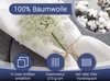 A close-up of white fabric napkins tied with twine, with a sprig of white flowers. Inset images show cotton bolls and icons representing product features. Produktbild-Vorschau