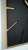 A close-up, angled view of a modern square wall clock with a black face and wooden accents. Anteprima dell’immagine prodotto
