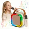 A young girl is happily singing into a microphone connected to a portable karaoke speaker with colorful RGB lights. Náhľad obrázku produktu