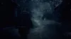 A person walks down a dark, foggy path in a forest with dilapidated structures on either side. Produktbild-Vorschau