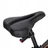 A close-up view of a black bicycle saddle with a small red light attached to the seat post. Produktbild-Vorschau