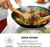 A person is cooking vegetables in a wok on a stovetop. Produktbild-Vorschau