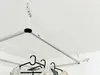 A ceiling-mounted clothes drying rack with clothes hanging on it. Voir les images du produit