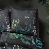 A close-up view of a duvet cover and pillow with a botanical print. Produktbild-Vorschau