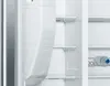 Interior view of an open refrigerator with shelves and water bottles. Náhled obrázku produktu