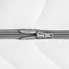 A close-up view of a zipper on a white, quilted surface. Produktbild-Vorschau