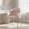 A pink upholstered chair with gold metal legs is shown in a well-lit room, possibly a bedroom or dressing area, next to a white vanity table. Produktbild-Vorschau