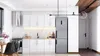 A modern kitchen with white cabinets, a stainless steel refrigerator, and a wooden ceiling. Produktbild-Vorschau