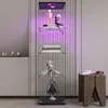 A modern display cabinet with collectible figures and books, placed next to a modern fireplace and a wooden stool. Náhled obrázku produktu