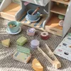 A wooden toy coffee and ice cream bar set with various accessories laid out on a carpeted floor. Anteprima dell’immagine prodotto