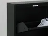A close-up view of a black shoe cabinet with a white sneaker inside. Voir les images du produit