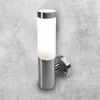 A modern, cylindrical wall lamp with a brushed metal base and a frosted glass diffuser, mounted on a textured gray concrete wall. Produktbild-Vorschau