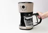 A hand is holding a coffee pot next to a coffee maker. Náhled obrázku produktu