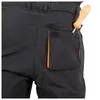 Close-up of the back pocket of black work pants with an orange trim, showing a screwdriver inserted into the pocket. Anteprima dell’immagine prodotto