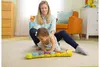 A mother and baby are playing with a musical worm toy on the floor. Produktbild-Vorschau