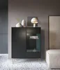 A modern black cabinet with glass doors and gold legs, decorated with vases and a lamp. Podgląd zdjęcia produktu