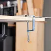 A close-up view of a clamp securing a wooden board to a metal rail, likely in a workshop setting. Produktbild-Vorschau