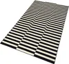 A rectangular rug with a black and white striped pattern is shown from a slightly elevated angle against a white background. Anteprima dell’immagine prodotto
