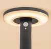 Close-up of the top of a black outdoor solar light with a circular illuminated ring and a motion sensor. Produktbild-Vorschau