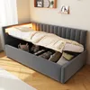 A daybed with storage is shown with bedding and some items in the storage compartment. The bed has a padded headboard with integrated LED lighting. Anteprima dell’immagine prodotto