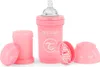 A pink baby bottle with its accessories laid out on a white background. Podgląd zdjęcia produktu