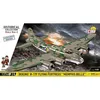 The image shows the packaging of a Cobi Boeing B-17F Flying Fortress "Memphis Belle" model kit, set against a dramatic, cloudy sky background with a hint of fire or smoke below. The model itself is prominently displayed on the box art, with two small figur Voir les images du produit