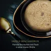 A close-up of a bowl of cat food with a golden spoon next to it, set against a dark, moody background. Voir les images du produit
